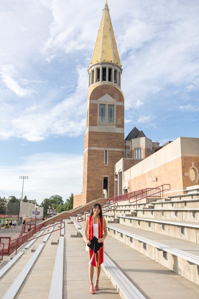 Graduate portrait at Williams Tower with gold steeple in background